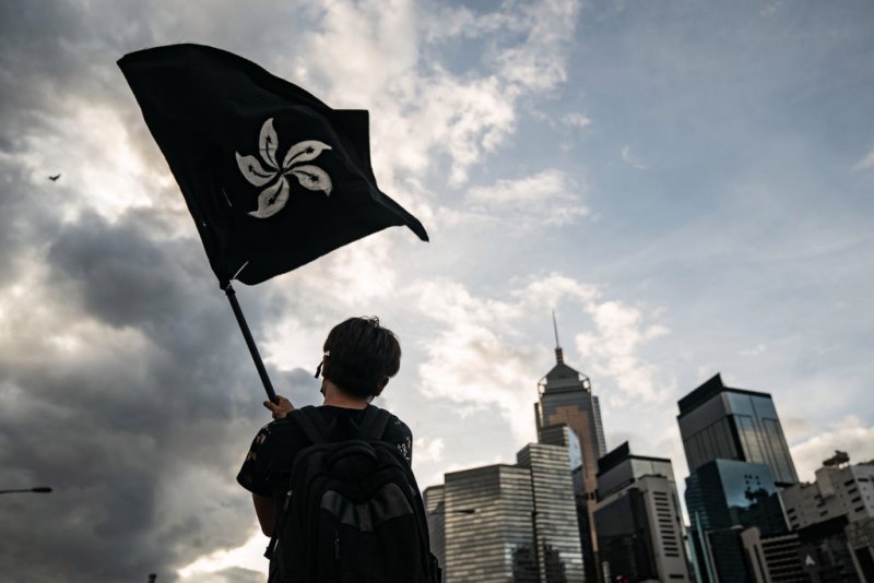  HK protestor waving the black bauhinia flag 